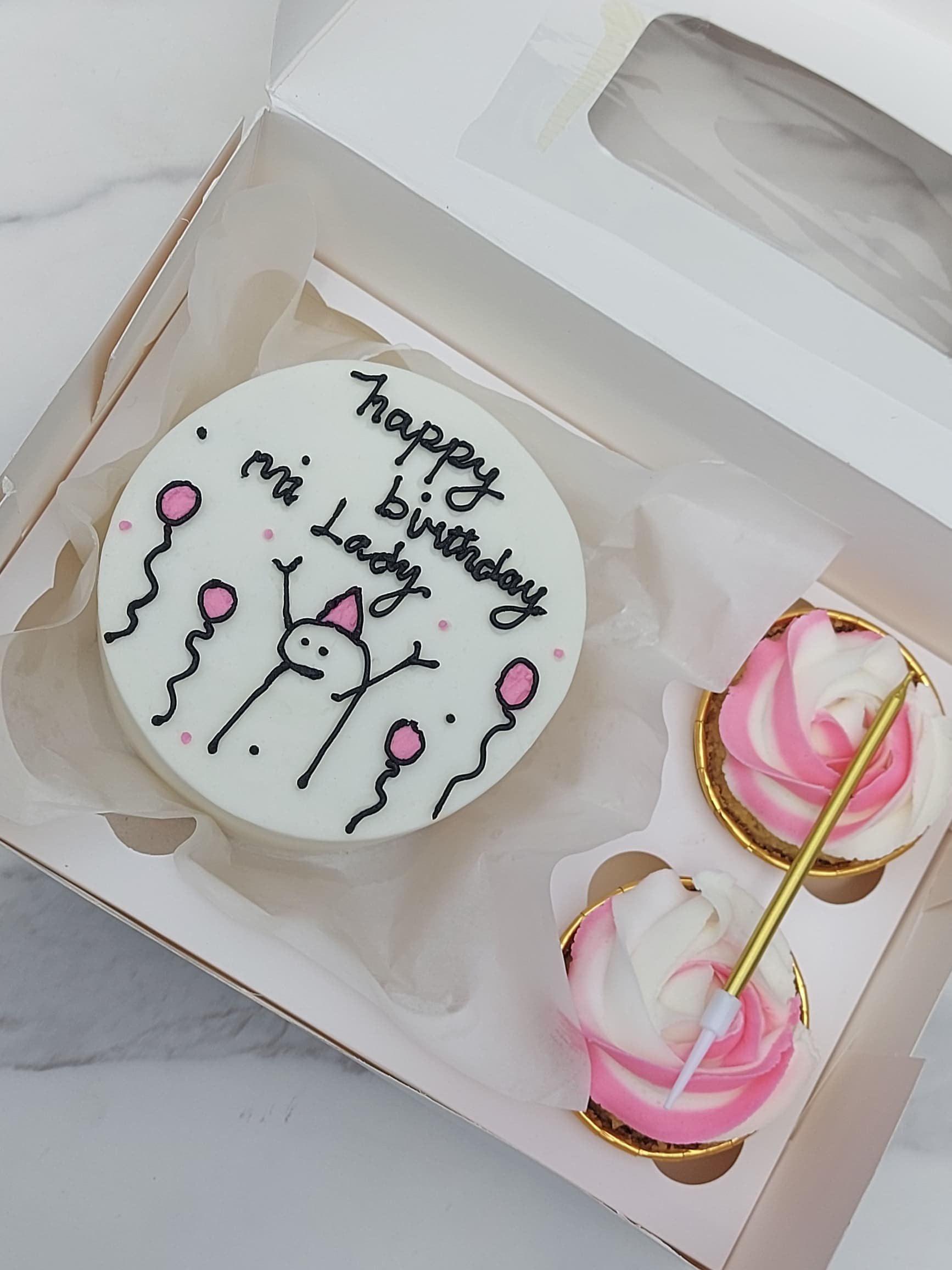 Hand-piped birthday cake with stick figure and balloons